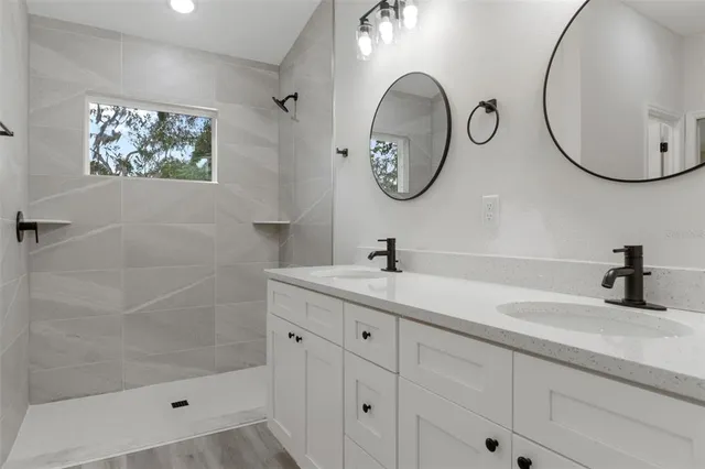 a bathroom with a sink a mirror and a shower