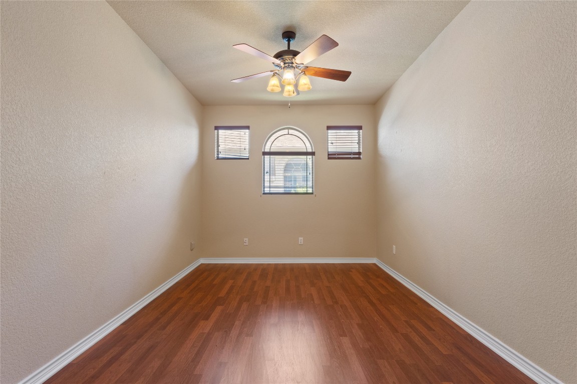 1005 Fort Davis Street Georgetown, TX 78633 - Photo 11 of 38 an empty room that has wooden floor a chandelier fan and a window