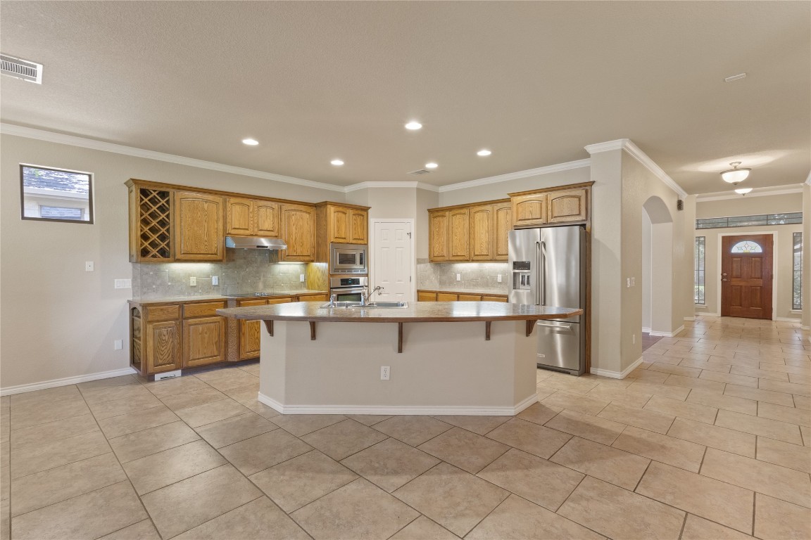 1005 Fort Davis Street Georgetown, TX 78633 - Photo 8 of 38 a kitchen with stainless steel appliances a refrigerator sink and cabinets