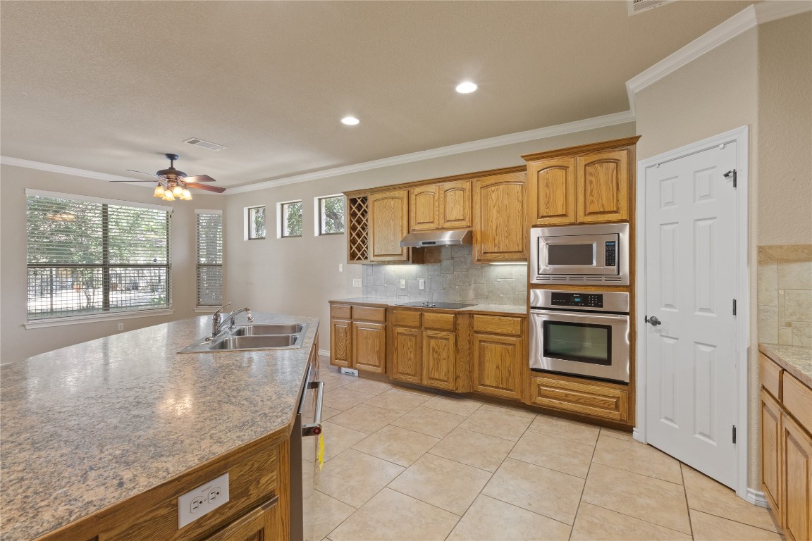 1005 Fort Davis Street Georgetown, TX 78633 - Photo 9 of 38 a kitchen with stainless steel appliances granite countertop a stove and a sink
