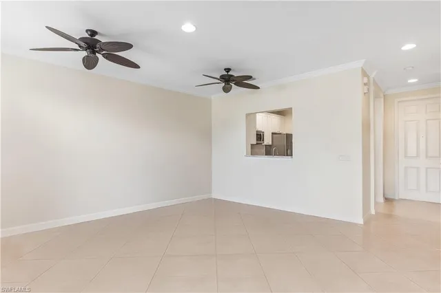 an empty room with a ceiling fan and windows