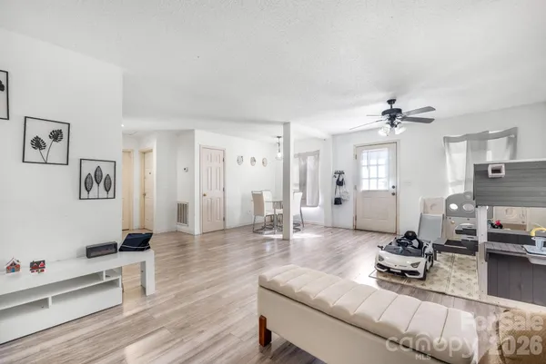 a living room with furniture a wooden floor and a chandelier