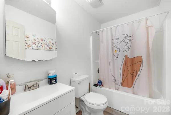 a bathroom with a toilet and a shower curtain