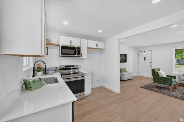 546 West 200 South Payson, UT 84651 - Photo 15 of 45 Bright kitchen featuring white cabinetry, light countertops, stainless steel appliances, and wood-finish flooring