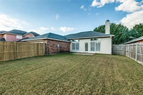 a view of a house with a backyard and a tree