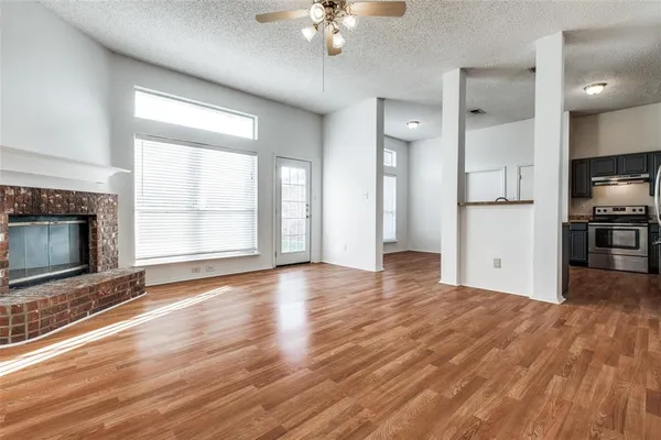 a view of an empty room with a fireplace and a window