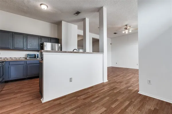 a kitchen with wooden floors and white cabinets