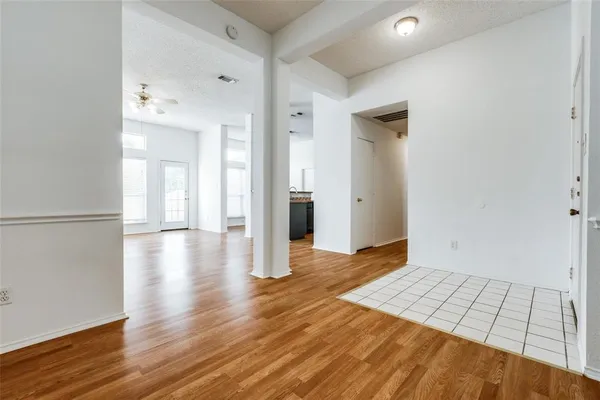 a view of an empty room with wooden floor