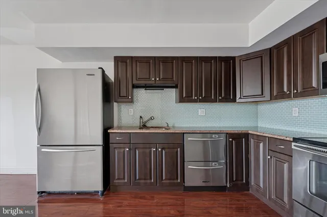a kitchen with a sink a refrigerator and cabinets