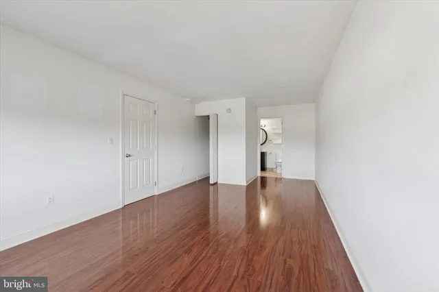a view of empty room with wooden floor and window