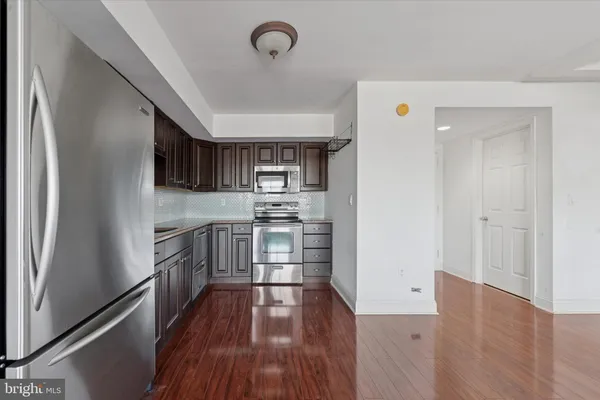 a kitchen with stainless steel appliances a refrigerator and a stove top oven