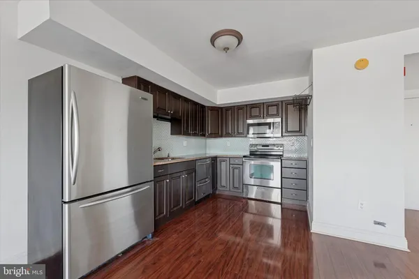 a kitchen with stainless steel appliances a refrigerator sink and microwave