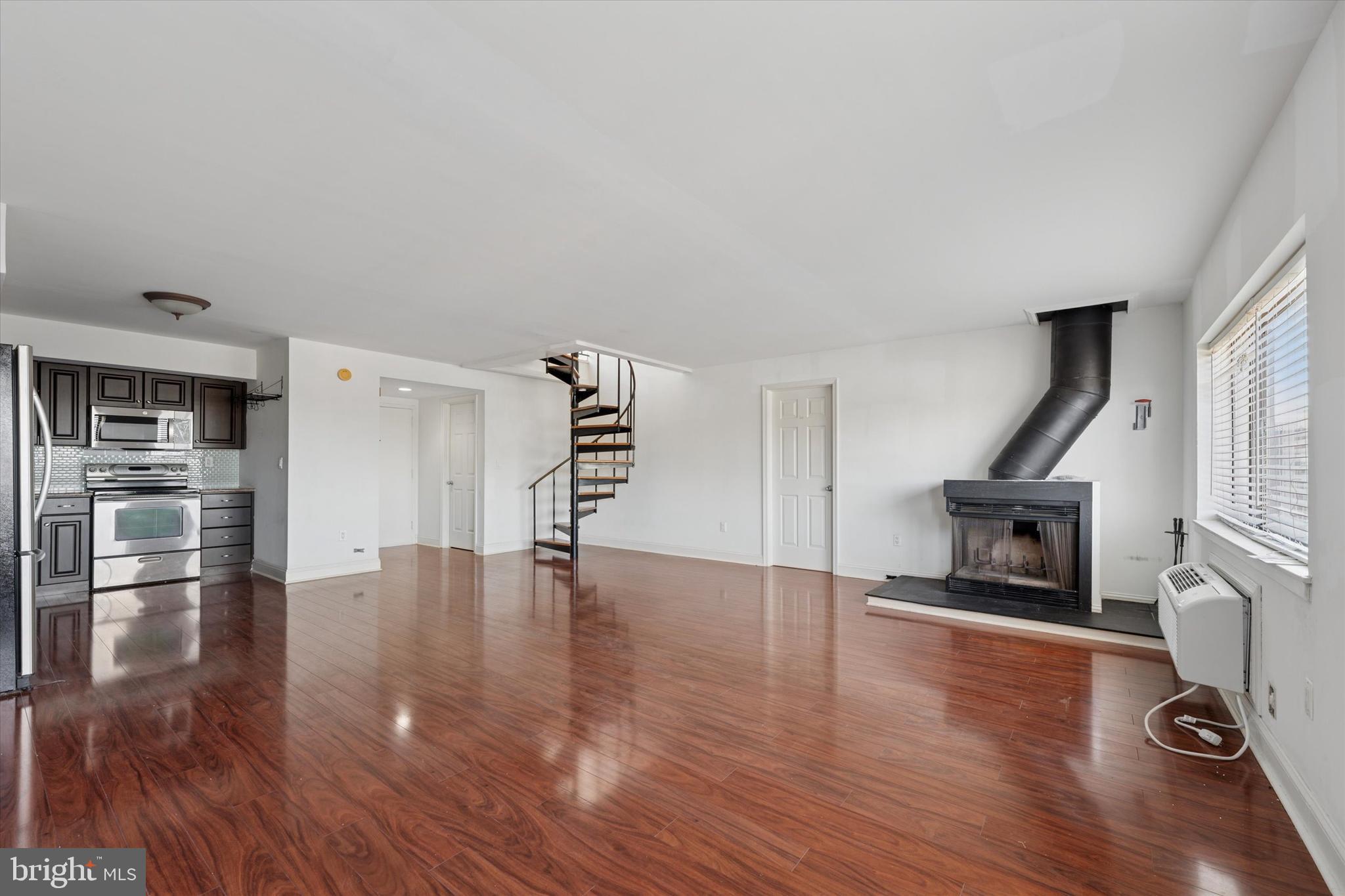 200 Lombard Street, Unit 804 Philadelphia, PA 19147 - Photo 6 of 15 a view of an empty room with wooden floor fire place and windows