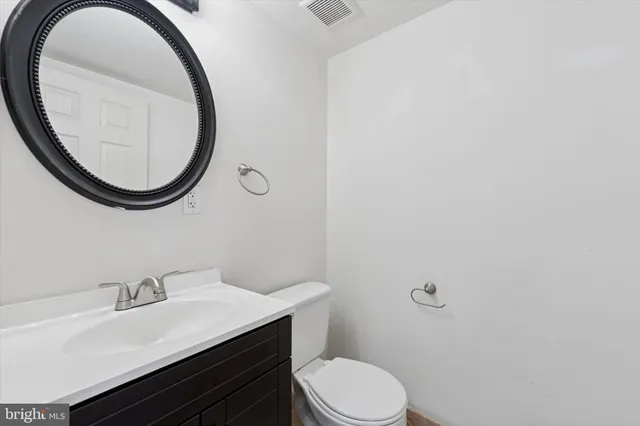a bathroom with a sink a toilet and a mirror