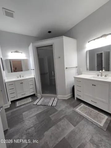 a spacious bathroom with a double vanity sink and mirror