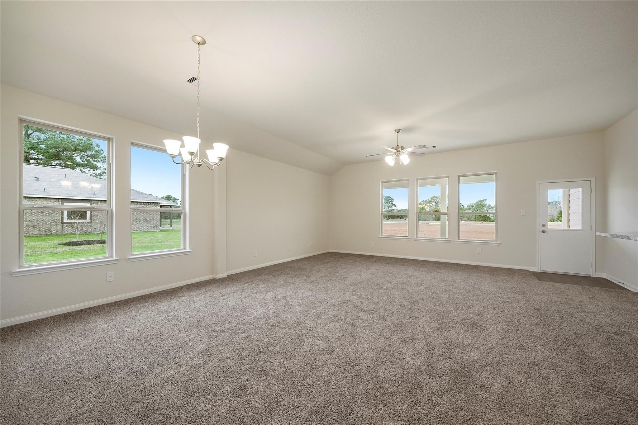 1435 Alice Drive Beaumont, TX 77705 - Photo 5 of 11 an empty room with windows and chandelier