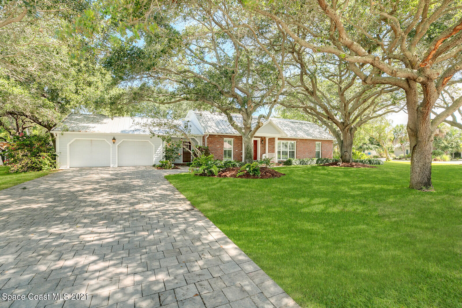 200 Melbourne Avenue Indialantic, FL 32903 - Photo 2 of 62 a front view of a house with a garden and trees