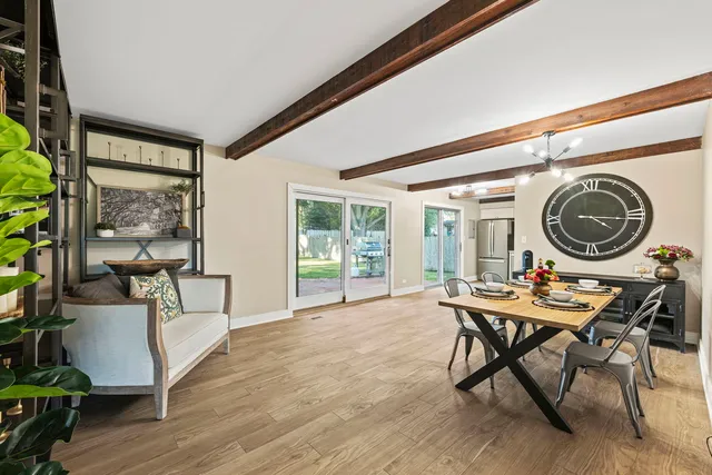 a living room with furniture a rug and a floor to ceiling window