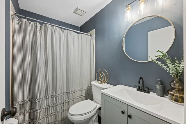 a bathroom with a toilet a sink and mirror