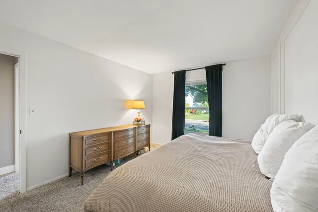 a bedroom with a bed dresser and a window