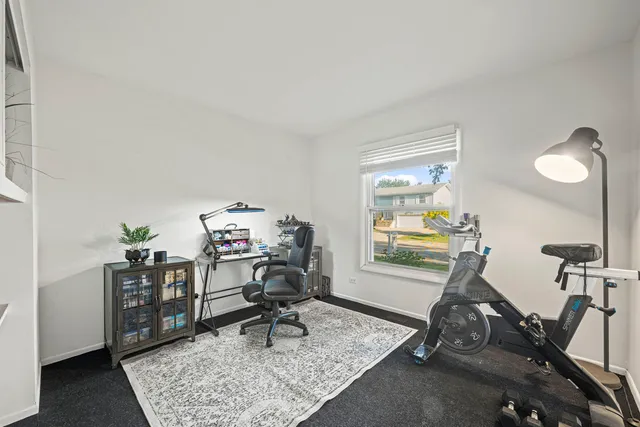 a view of a workspace with furniture and a window