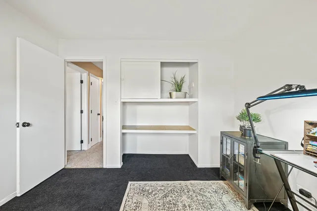 a living room with a couch and a dining table with wooden floor