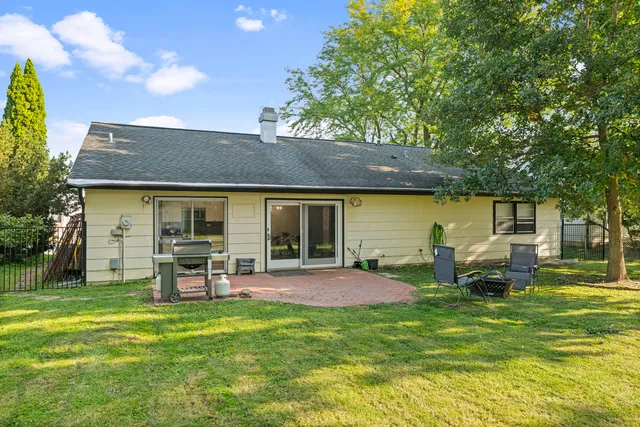 a view of a patio with table and chairs under an umbrella