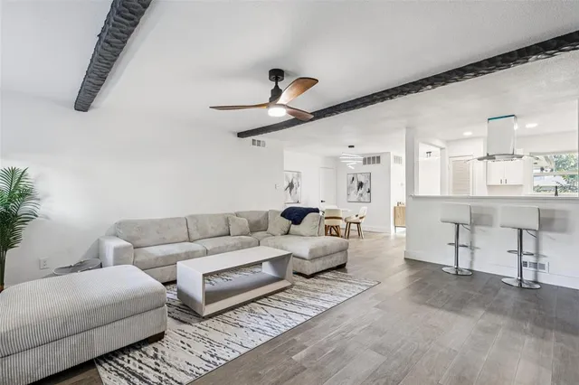 a living room with furniture and a ceiling fan