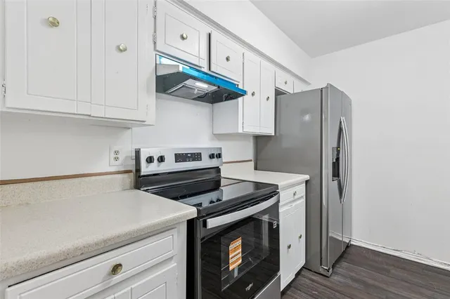a kitchen with stainless steel appliances granite countertop a stove a refrigerator and a microwave