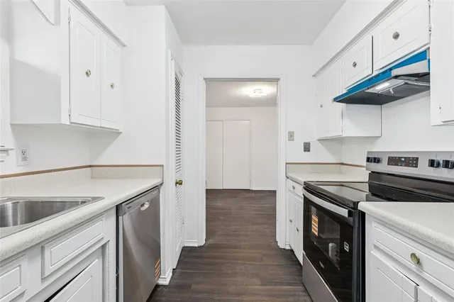 a kitchen with a stove sink and cabinets