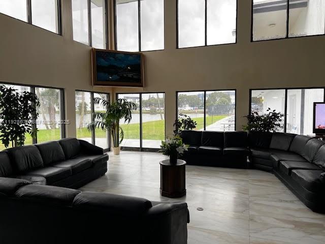 4751 Northwest 21st Street, Unit 605 Lauderhill, FL 33313 - Photo 11 of 12 a living room with furniture tv and a floor to ceiling window