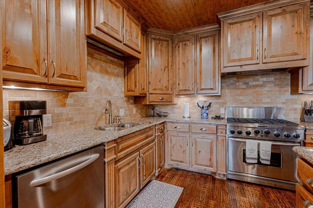 2033 Harbor Way, Unit 103 Graford, TX 76449 - Photo 5 of 22 a kitchen with stainless steel appliances granite countertop a sink a stove and cabinets