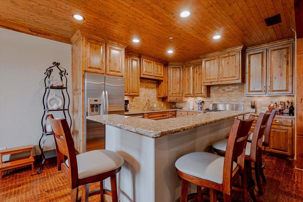 2033 Harbor Way, Unit 103 Graford, TX 76449 - Photo 7 of 22 a kitchen with stainless steel appliances granite countertop a table chairs sink refrigerator and cabinets