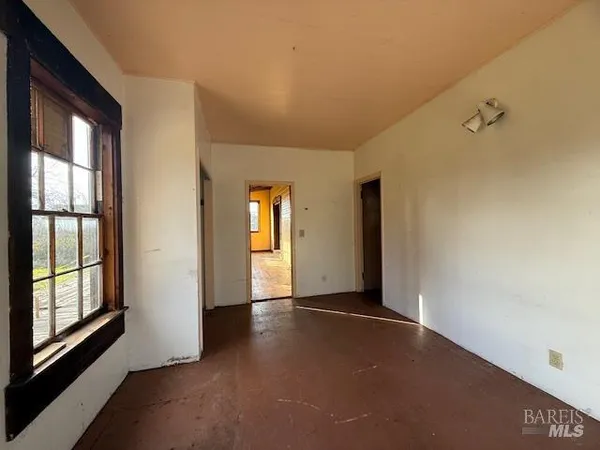 a view of a livingroom with an empty space and a window