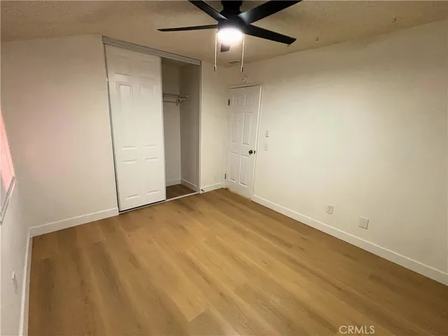 an empty room with a ceiling fan and carpet