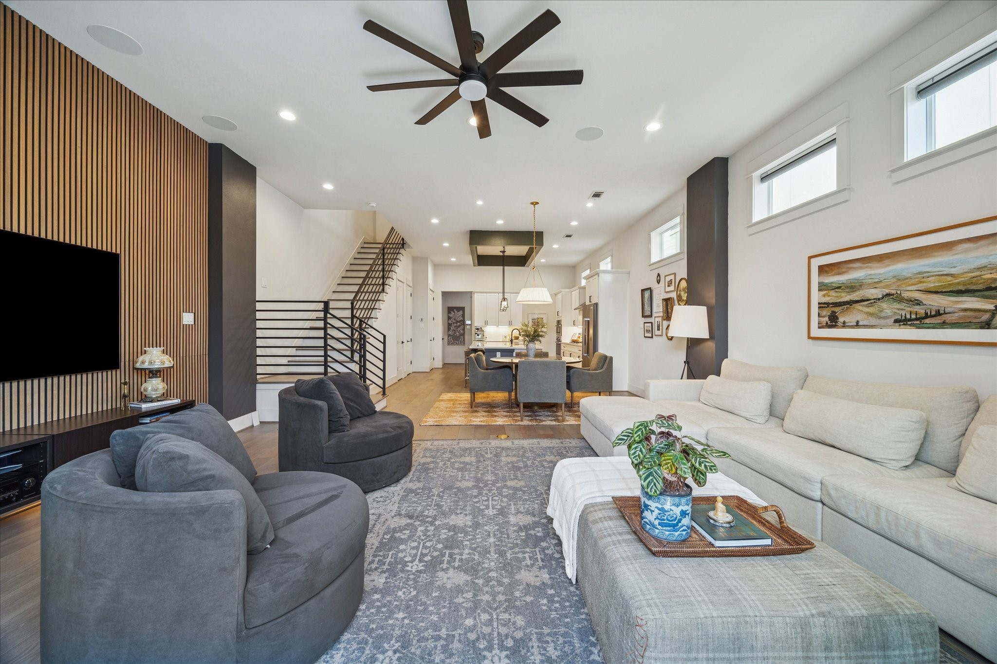 a living room with furniture kitchen view and a flat screen tv