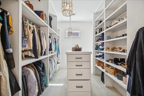 a view of walk in closet with clothes and shoes