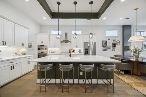 a kitchen with stainless steel appliances lots of counter top space and wooden floor