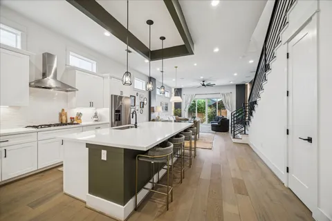 a large white kitchen with a stove and a large window