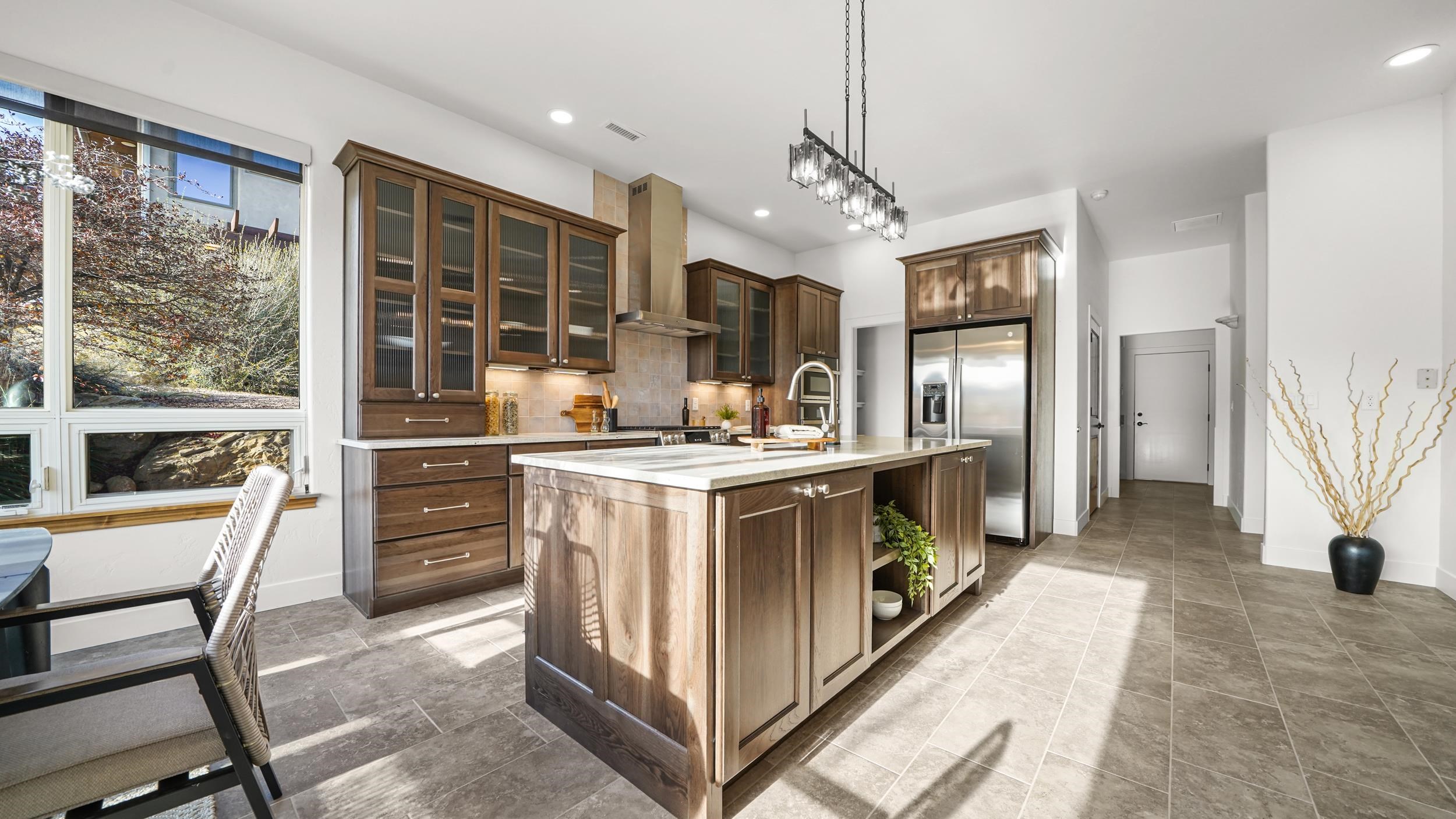372 High Desert Road Grand Junction, CO 81507 - Photo 5 of 40 a kitchen with kitchen island granite countertop a stove and a refrigerator