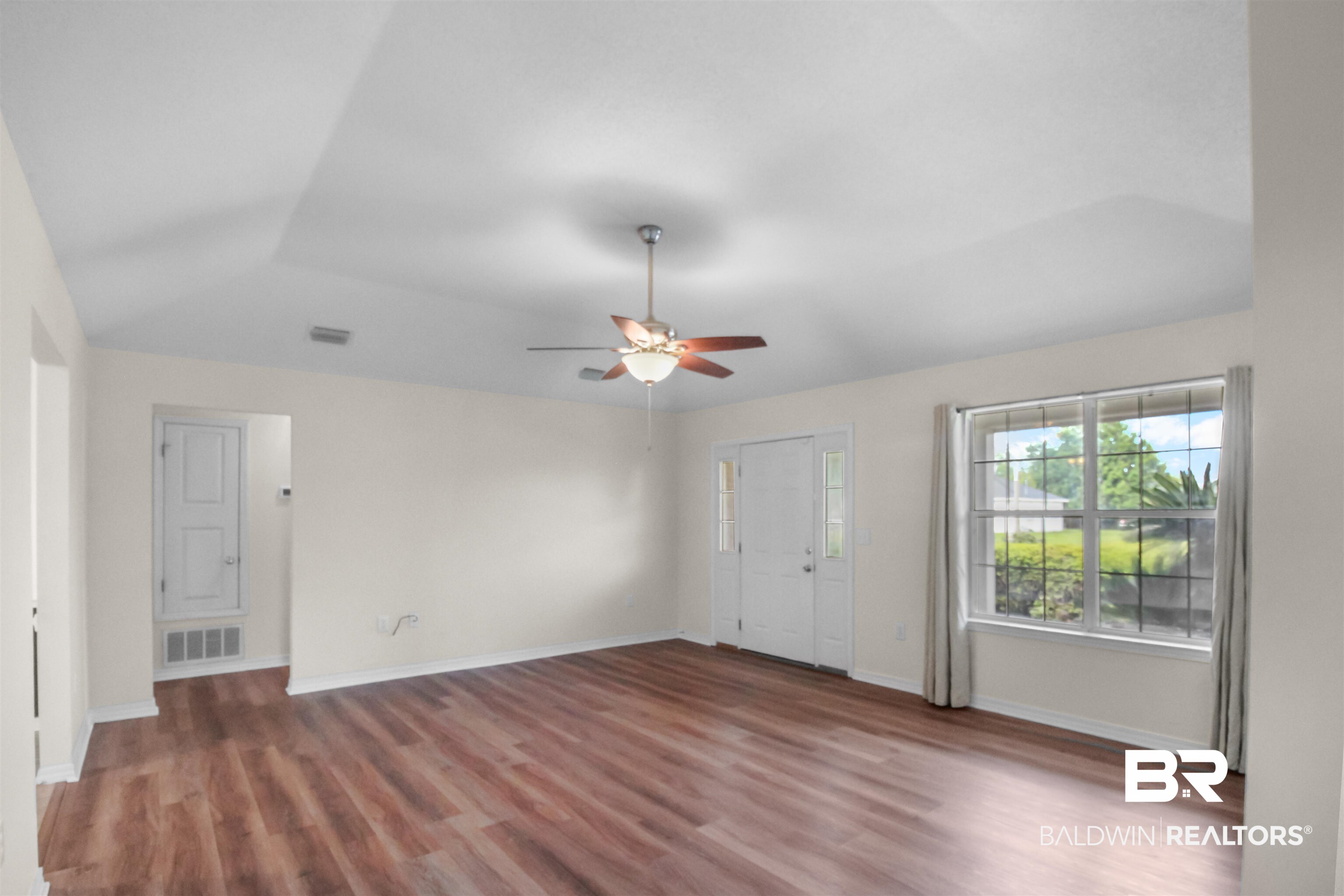 8940 Caitlin Street Foley, AL 36535 - Photo 6 of 27 Unfurnished living room featuring dark wood-type flooring and a ceiling fan