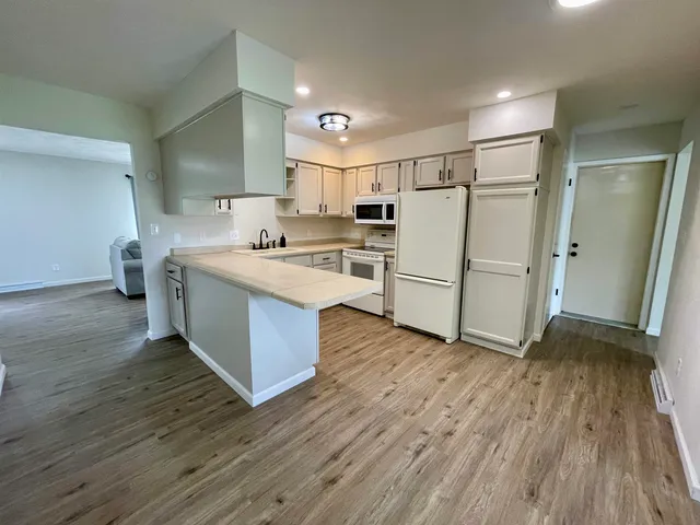 a kitchen with a refrigerator and a stove top oven
