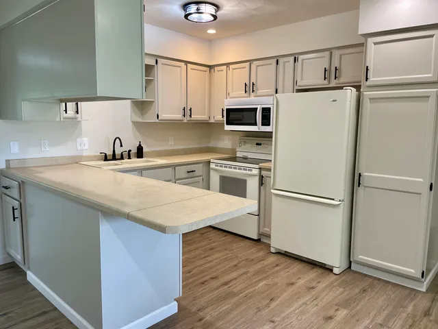 a kitchen with appliances a sink and a refrigerator