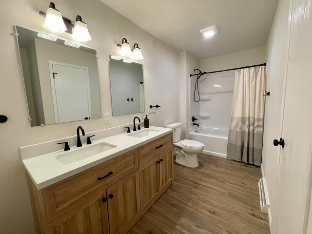 a bathroom with a double vanity sink mirror and toilet