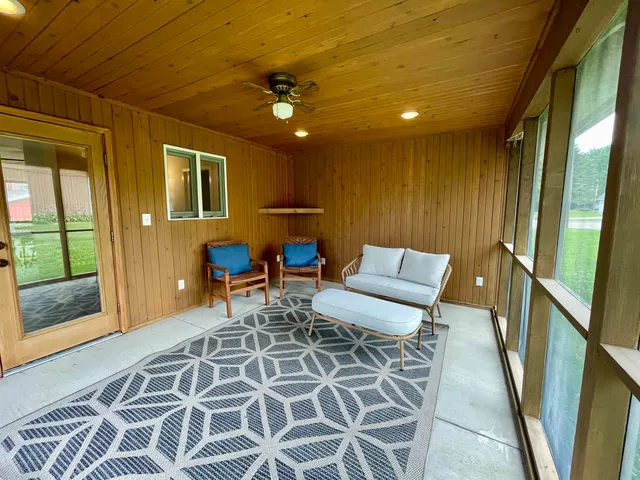 a dining room with furniture and a floor to ceiling window