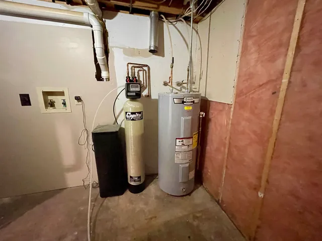 a view of storage and utility room with water heater and racks