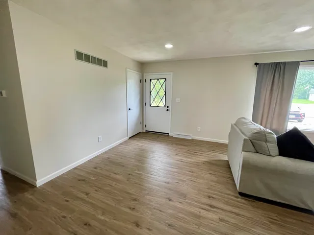 a living room with furniture and a hard wood floor