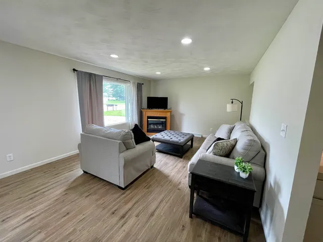 a living room with couches and a flat screen tv with wooden floor