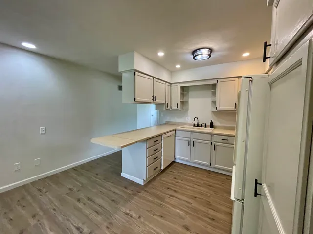 a kitchen with white cabinets and white appliances