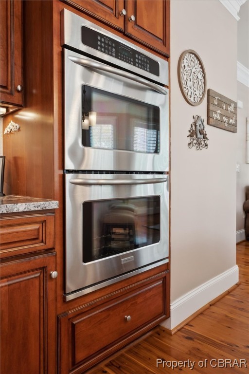 3013 Ridge Drive Toano, VA 23168 - Photo 19 of 50 Kitchen featuring baseboards, wood finished floors, brown cabinetry, ornamental molding, and double oven